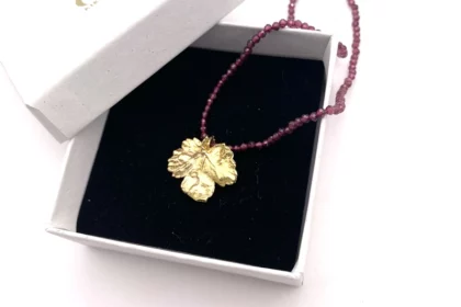 Collier de grenat avec pendentif feuille de vigne dorée