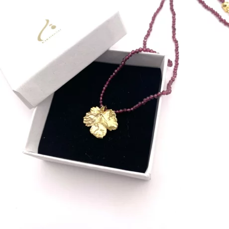 Collier de grenat avec pendentif feuille de vigne dorée